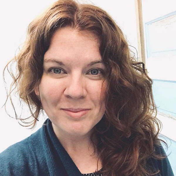 Rachel Cherry is white and identifies as female. She is in her mid 30s with fairly pale skin and long auburn colored hair.